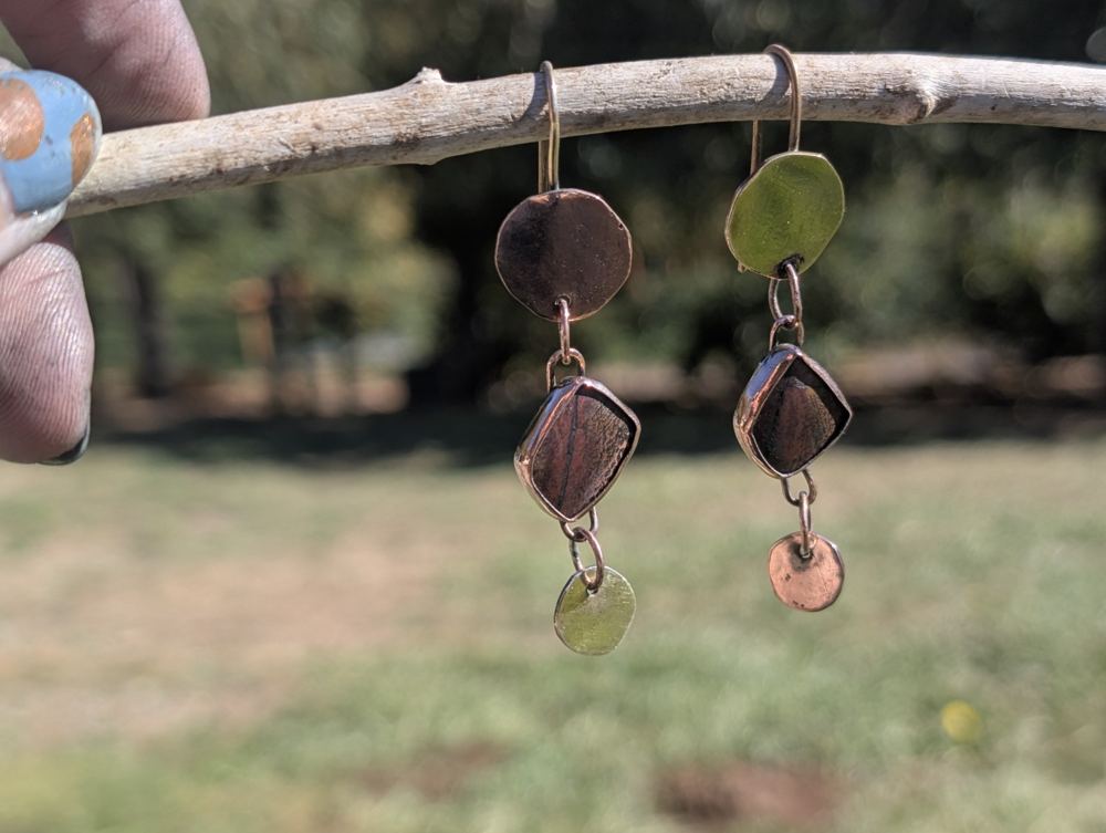 Brown patterned stones between contrasting copper-colored and gold-colored circular links.